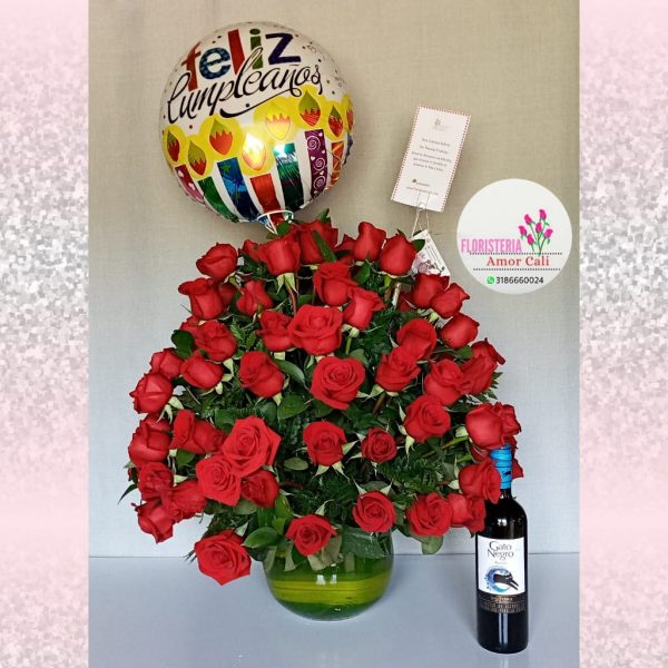 Arreglo floral redondo en rosas rojas y licor