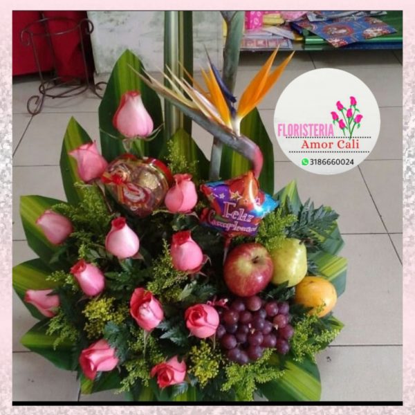 Arreglo floral con rosas fucsia y frutas