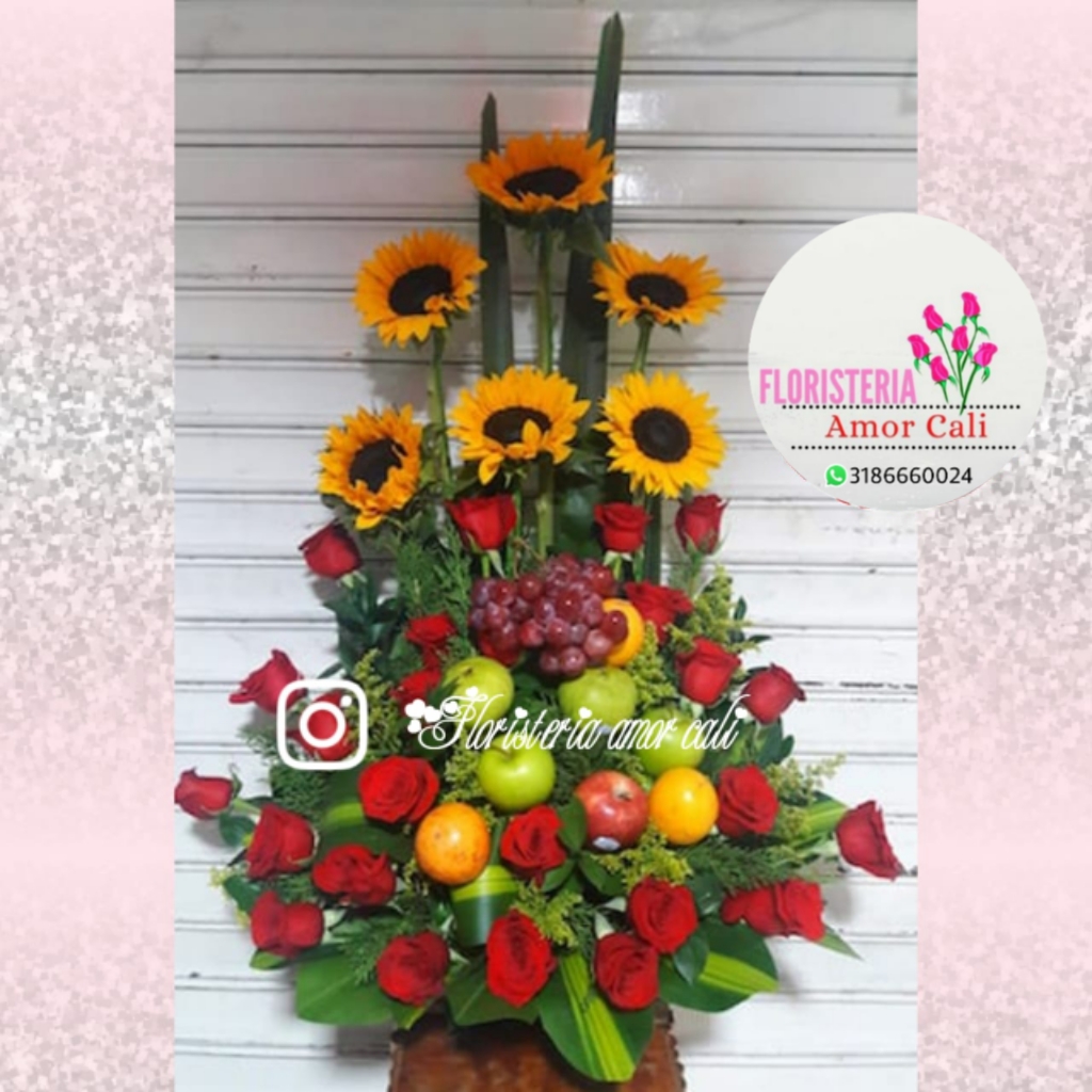 Arreglo floral rosas rojas girasoles y frutas -