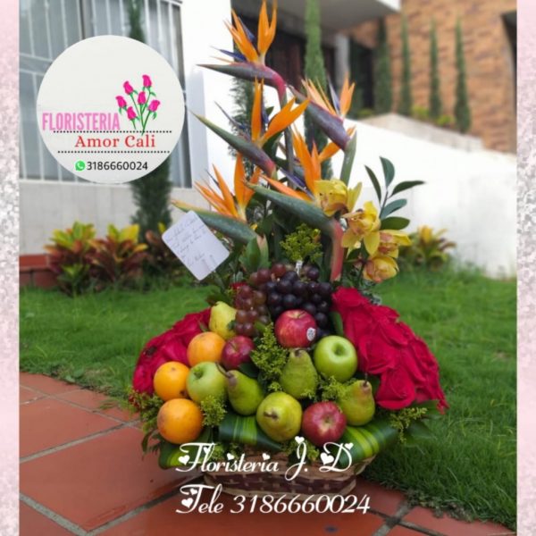 Arreglo floral con frutas rosas rojas y flores exóticas